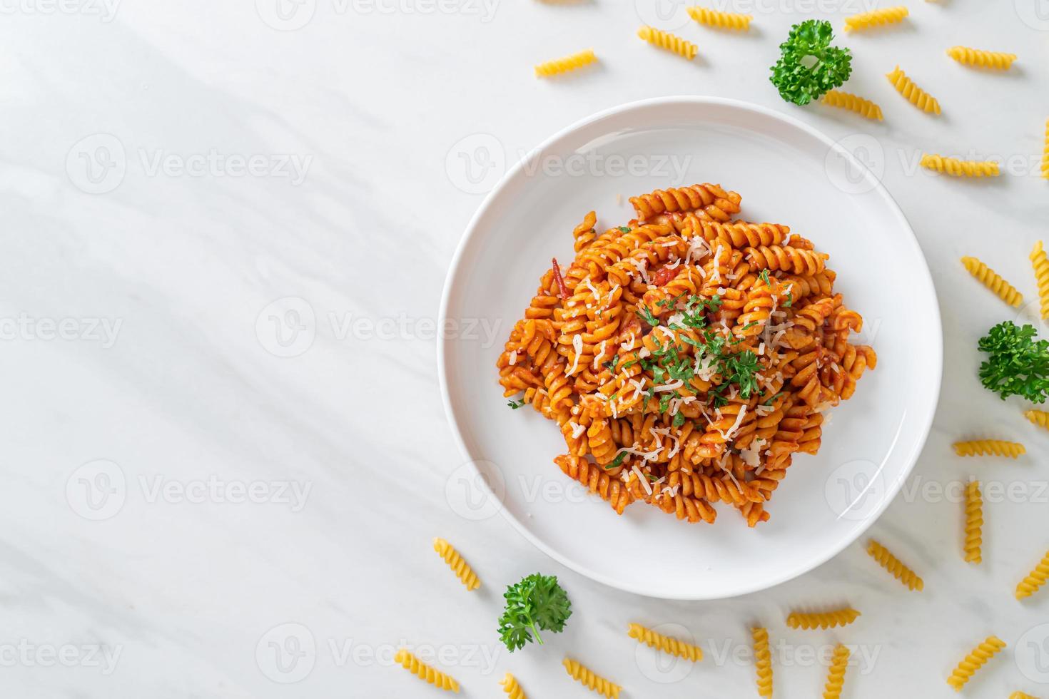 pasta a spirale o spirali con salsa di pomodoro e salsiccia - stile italiano foto