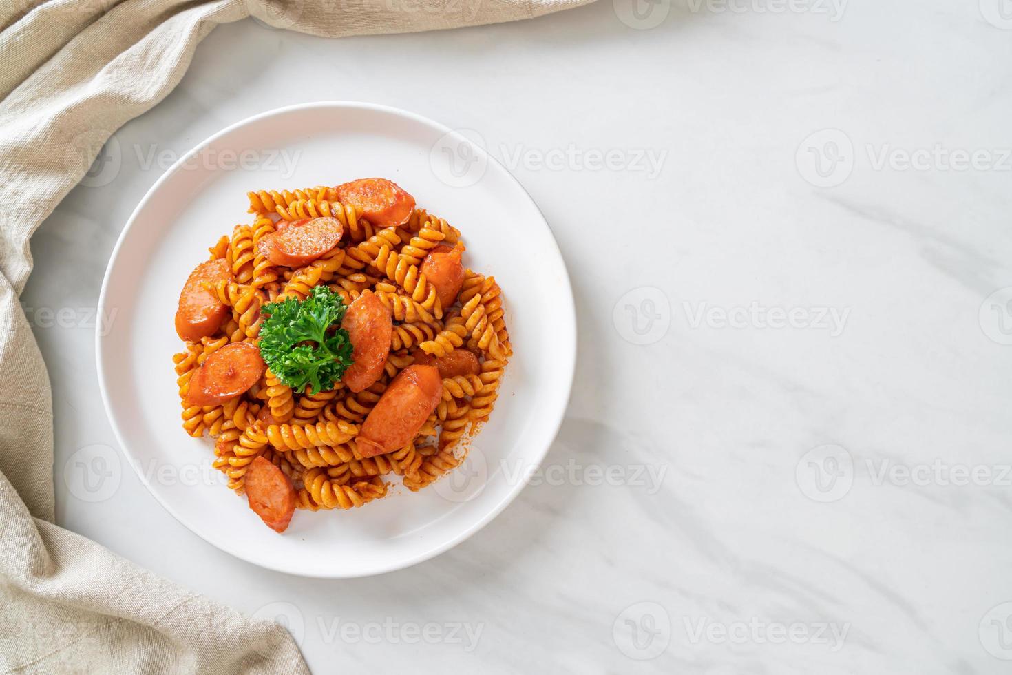 pasta a spirale o spirali con salsa di pomodoro e salsiccia - stile italiano foto