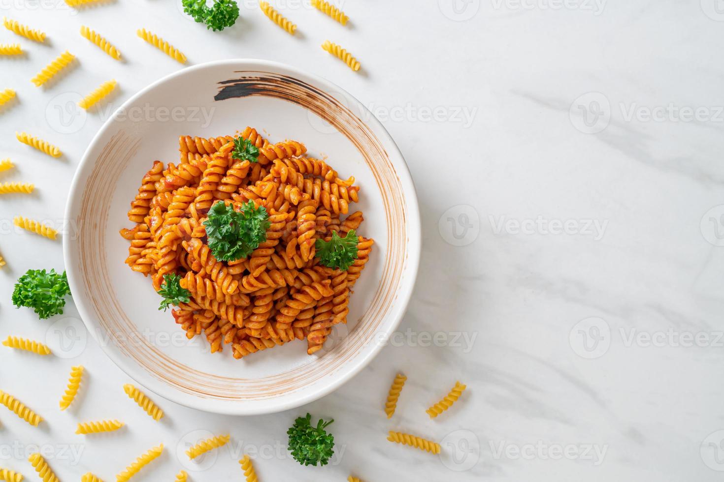 pasta a spirale o spirali con salsa di pomodoro e salsiccia - stile italiano foto