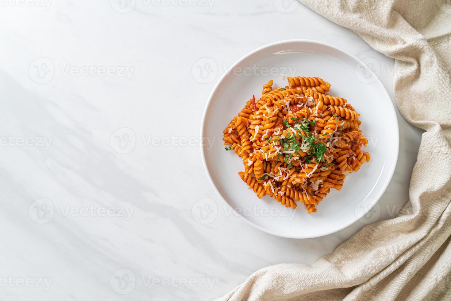 pasta a spirale o spirali con salsa di pomodoro e salsiccia - stile italiano foto