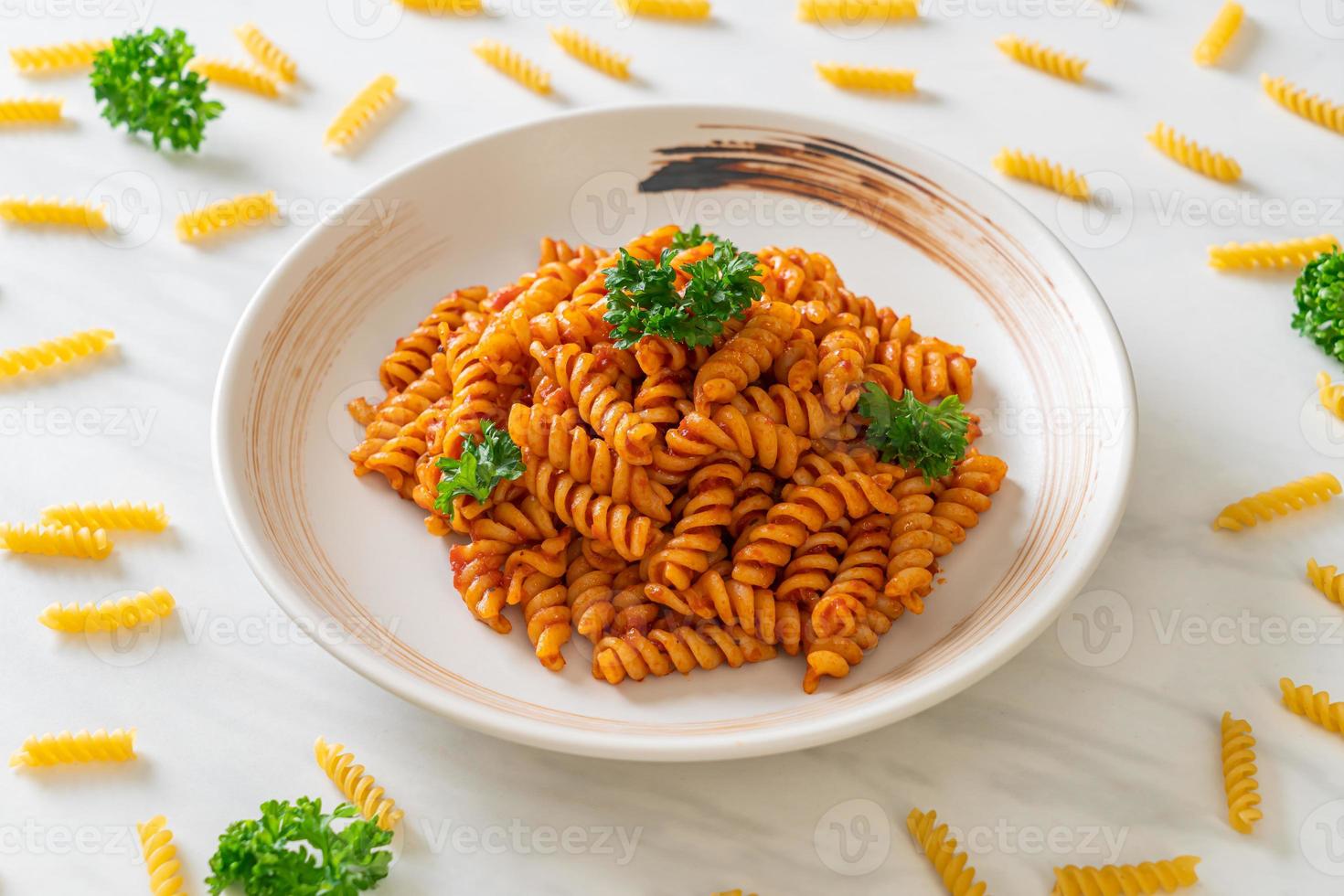 pasta a spirale o spirali con salsa di pomodoro e salsiccia - stile italiano foto