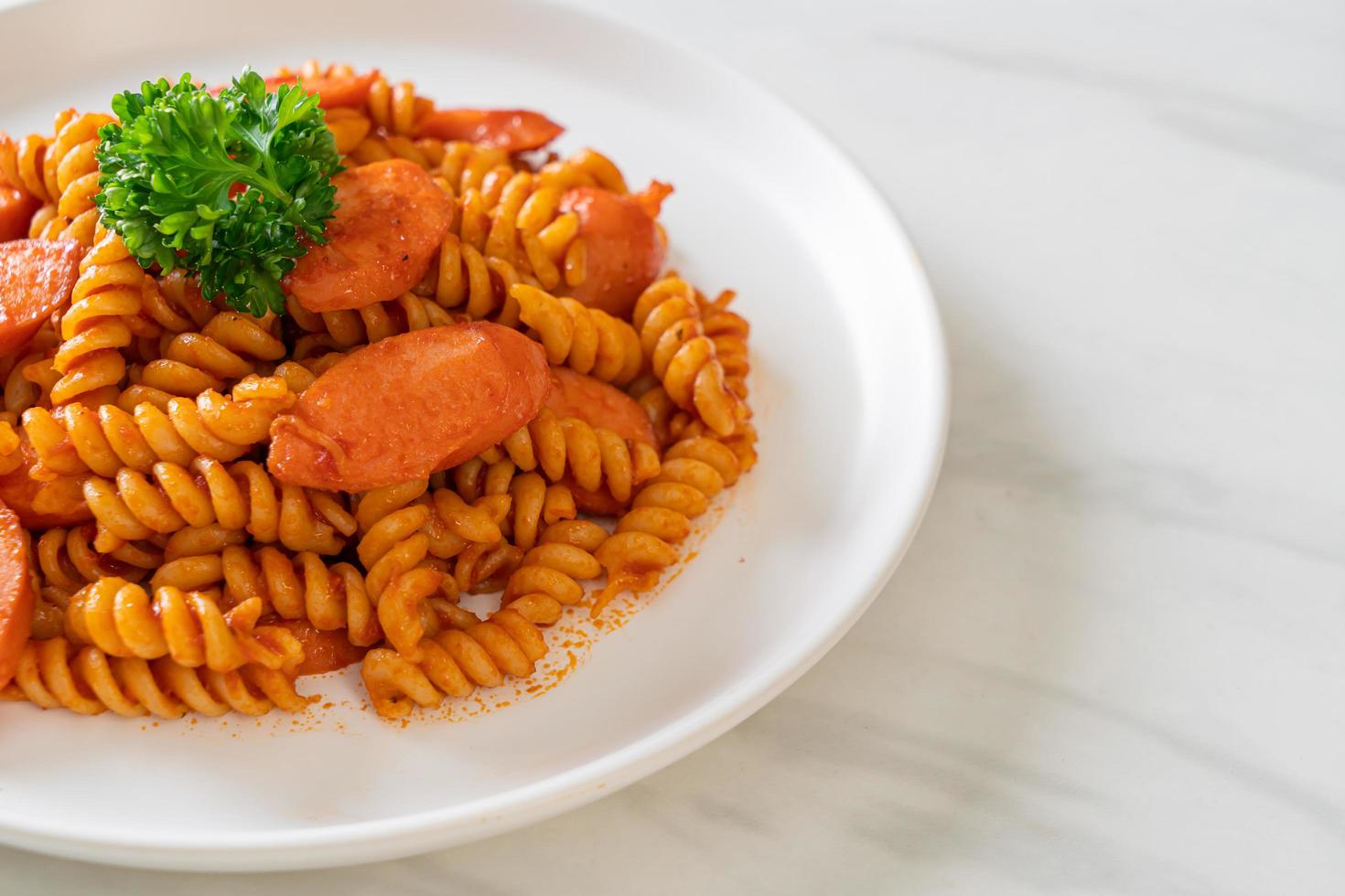 pasta a spirale o spirali con salsa di pomodoro e salsiccia - stile italiano foto