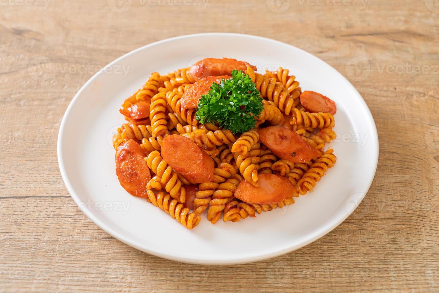 pasta a spirale o spirali con salsa di pomodoro e salsiccia - stile italiano foto