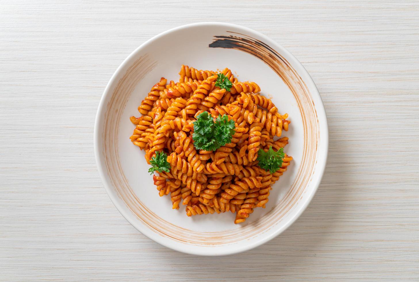 pasta a spirale o spirali con salsa di pomodoro e salsiccia - stile italiano foto