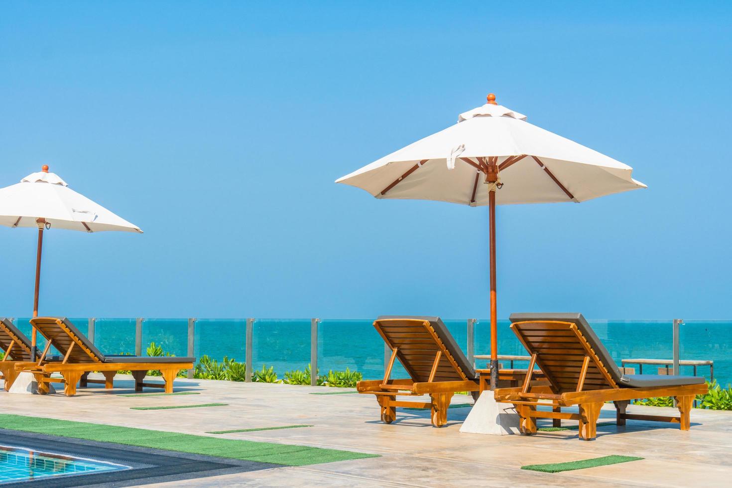 bellissimo ombrellone e sedia intorno alla piscina in hotel e resort foto