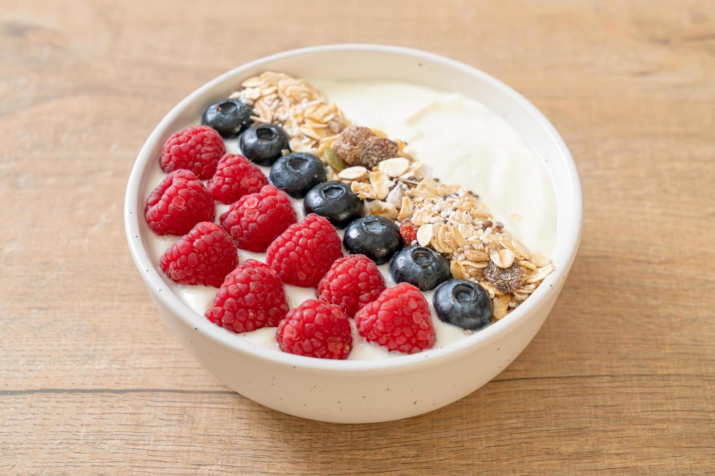 ciotola di yogurt fatta in casa con lampone, mirtillo e muesli - stile di cibo sano foto