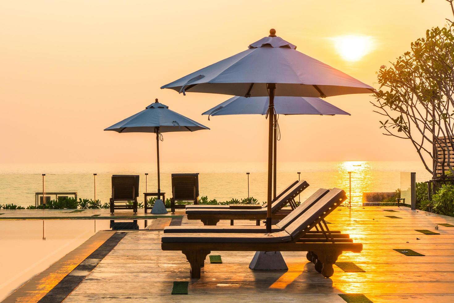 bellissimo ombrellone e sedia intorno alla piscina in hotel e resort foto