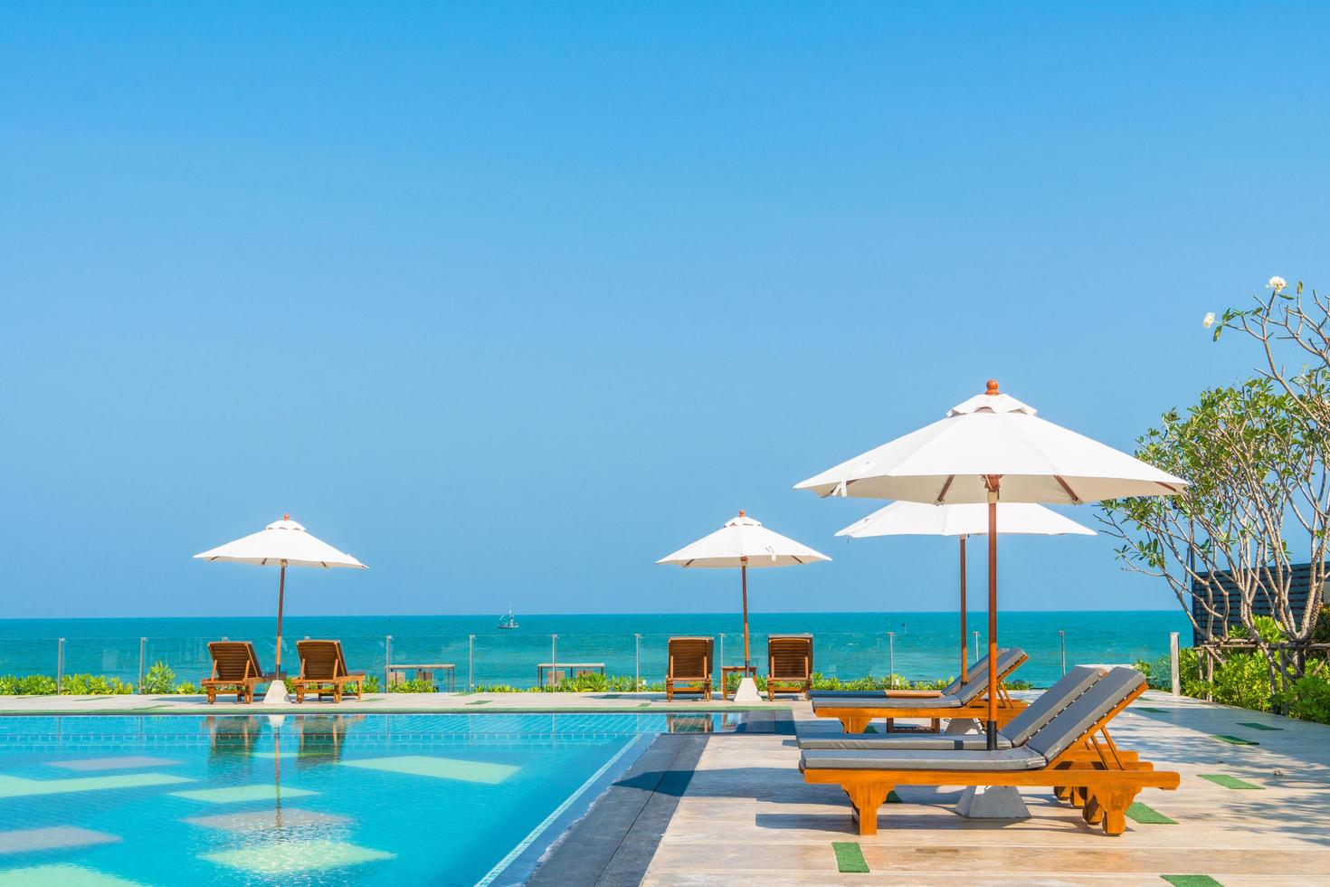 bellissimo ombrellone e sedia intorno alla piscina in hotel e resort foto