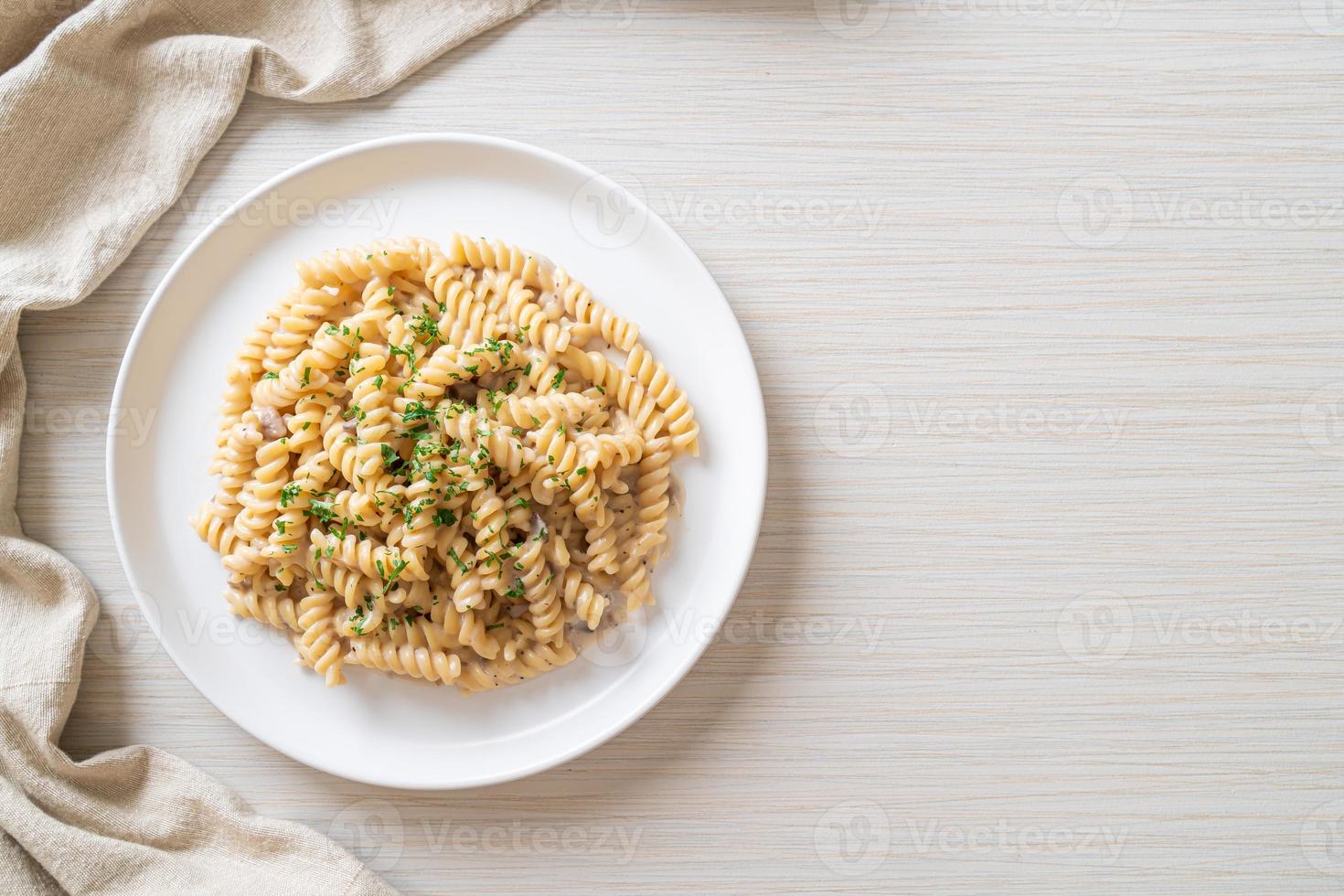 spirali o pasta a spirale salsa di crema di funghi con prezzemolo - stile alimentare italiano foto