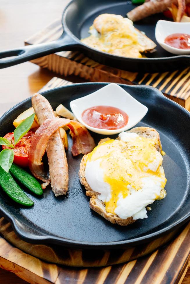 uovo alla benedict con salsiccia pancetta e salsa di pomodoro foto