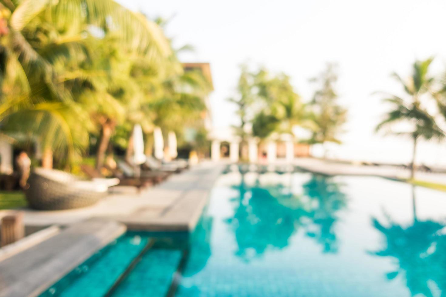 sfocatura astratta piscina all'aperto con palme da cocco foto