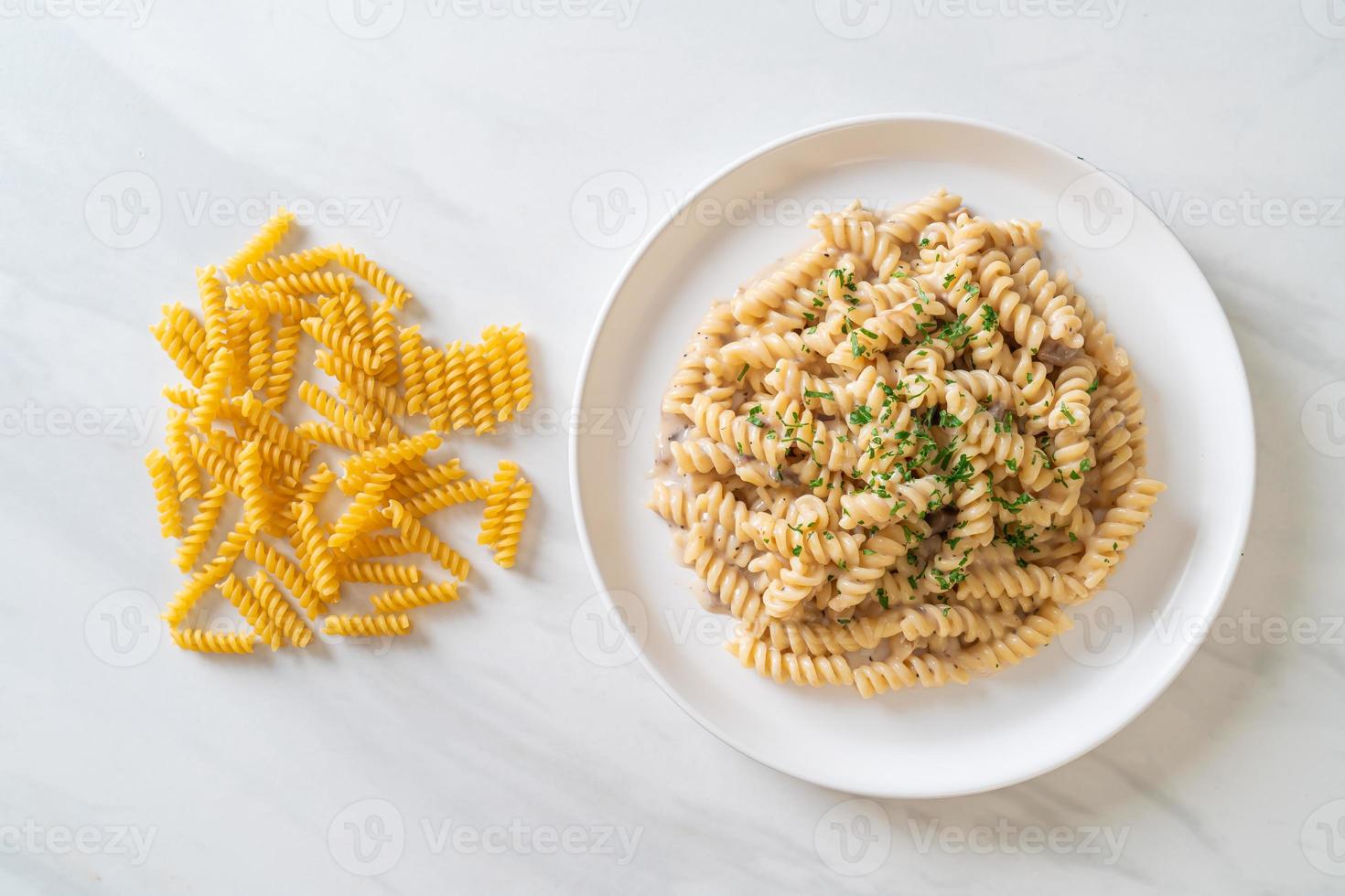 spirali o pasta a spirale salsa di crema di funghi con prezzemolo - stile alimentare italiano foto