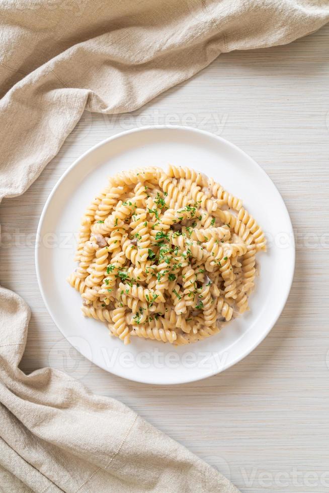 spirali o pasta a spirale salsa di crema di funghi con prezzemolo - stile alimentare italiano foto