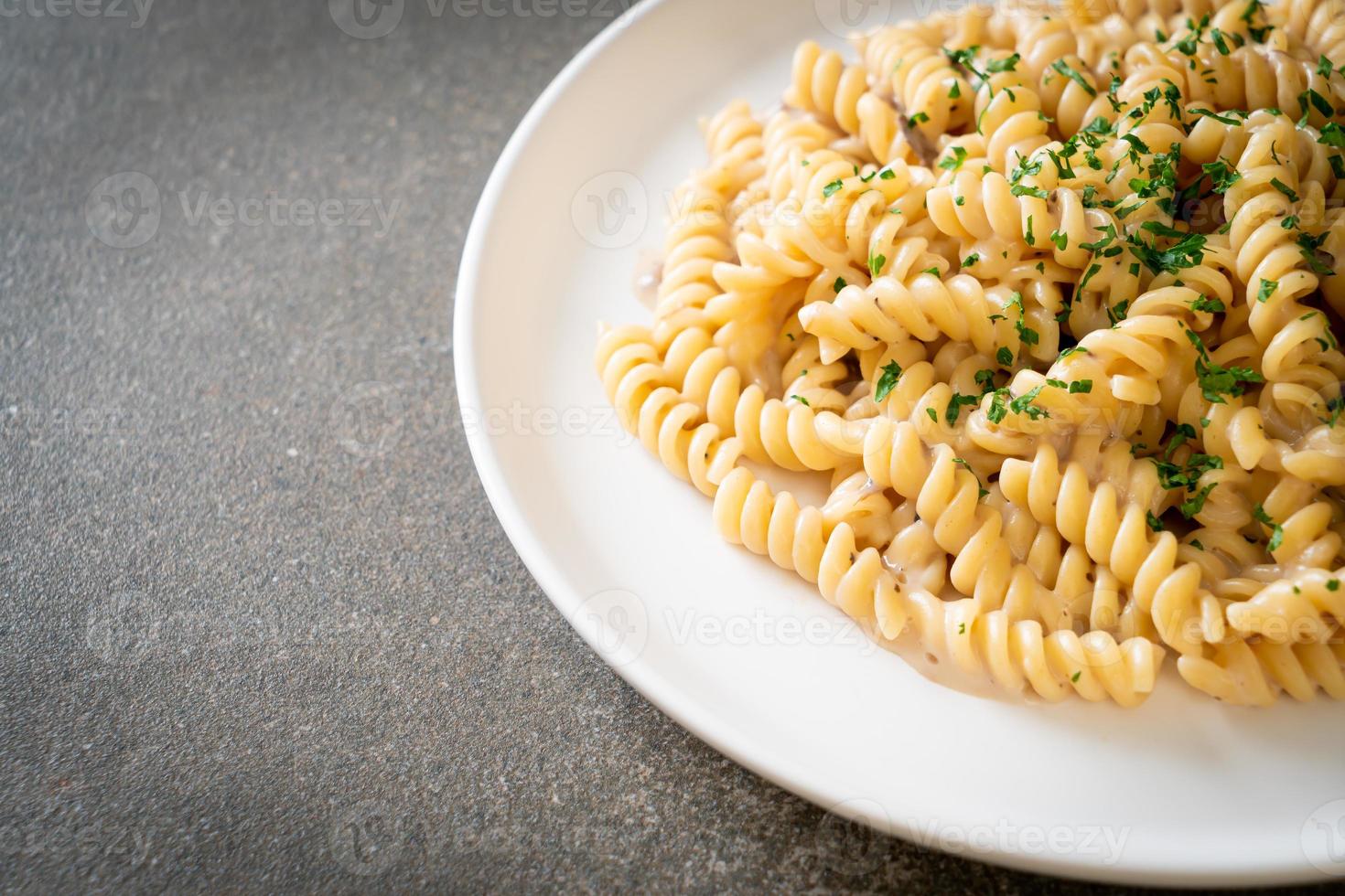 spirali o pasta a spirale salsa di crema di funghi con prezzemolo - stile alimentare italiano foto