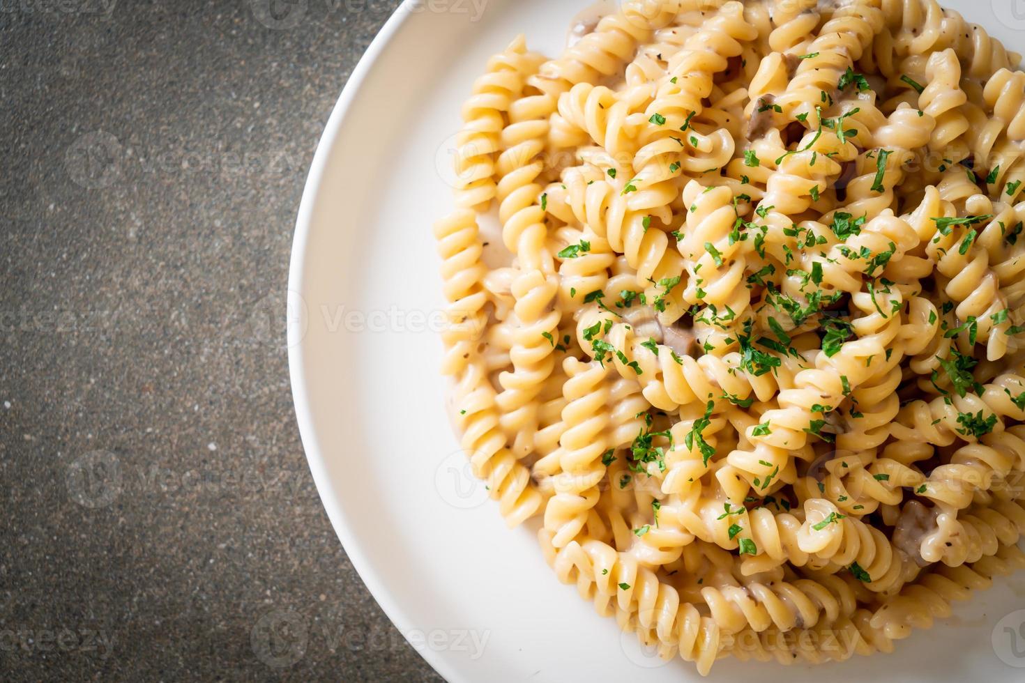 spirali o pasta a spirale salsa di crema di funghi con prezzemolo - stile alimentare italiano foto