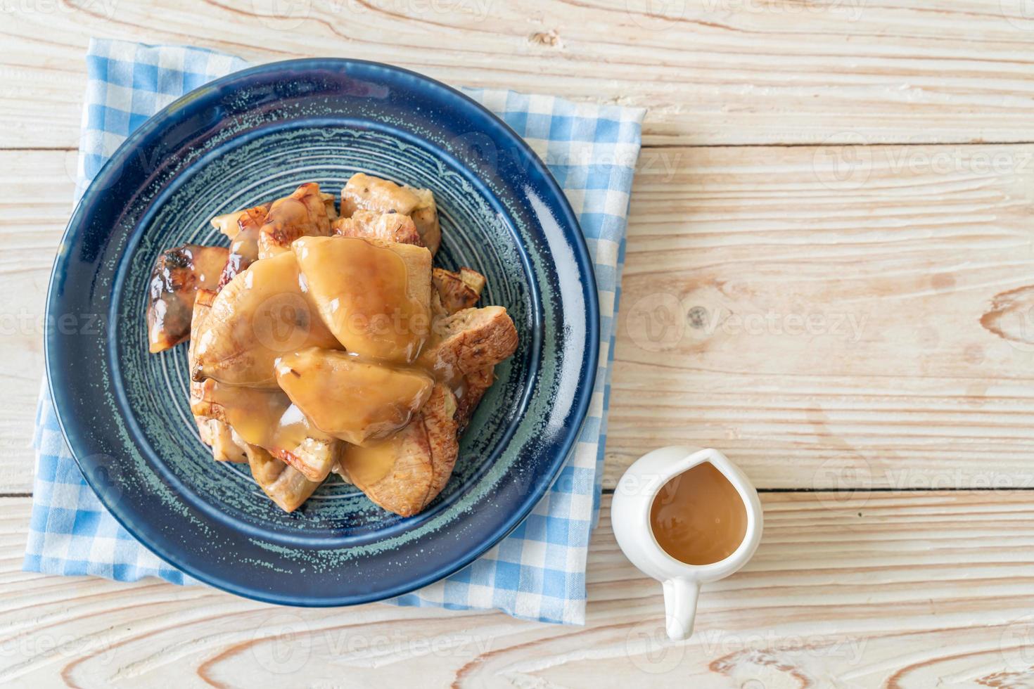 banane grigliate con salsa al caramello al cocco sul piatto foto