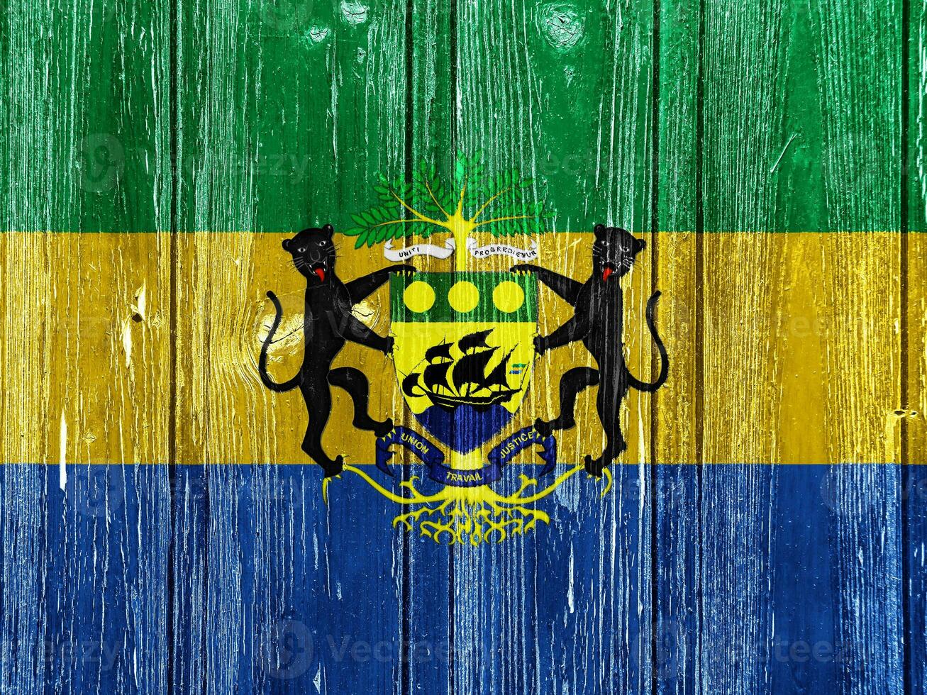 bandiera e cappotto di braccia di repubblica di Gabon su un' strutturato sfondo. concetto collage. foto