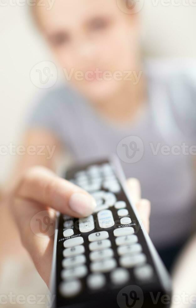 giovane donna con a distanza Guardando tv. foto