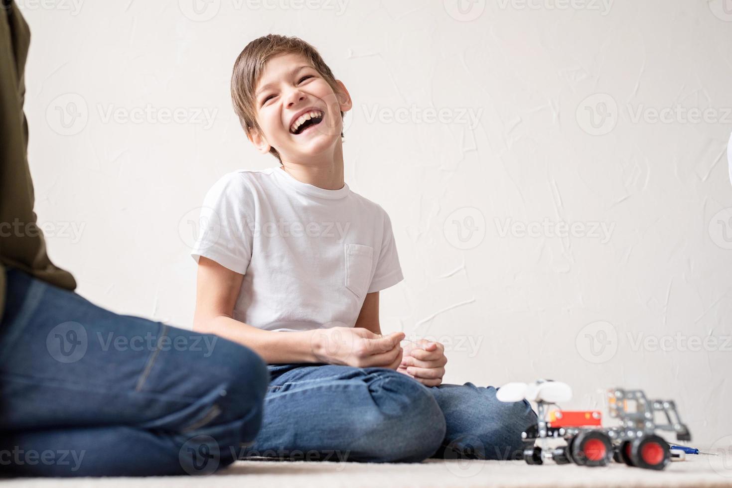 giovani ragazzi che si divertono a costruire auto robot in officina foto