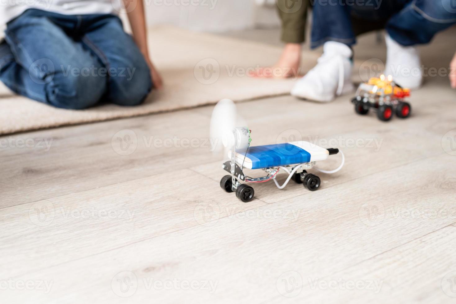 giovani ragazzi che si divertono a costruire auto robot in officina foto