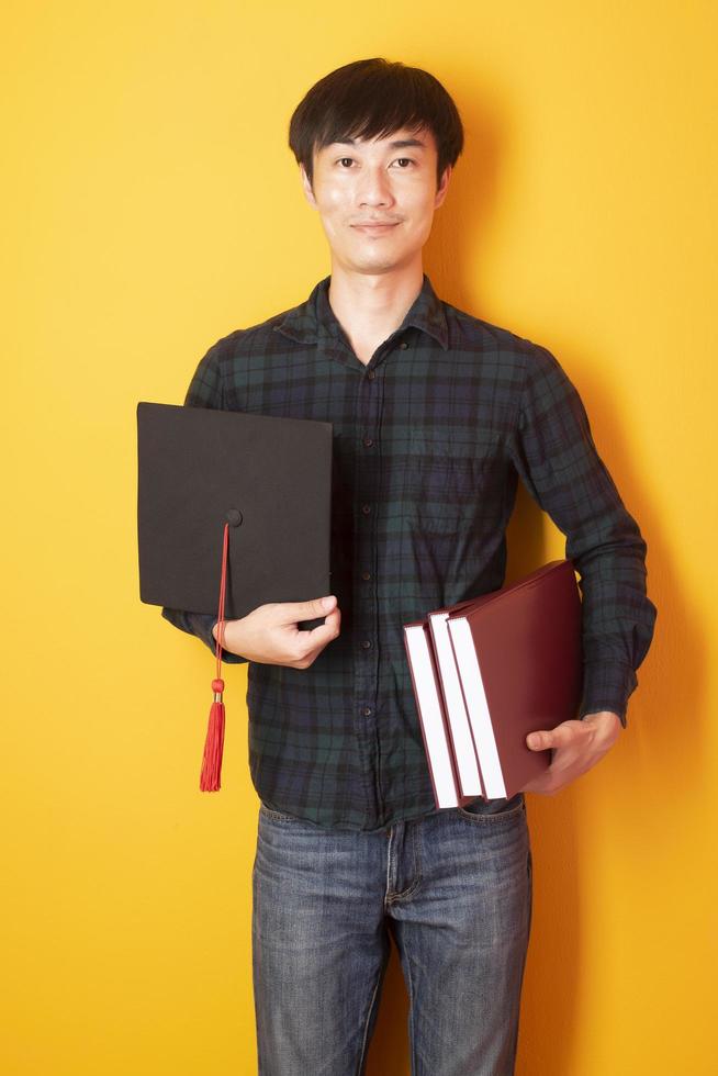 l'uomo dell'università è felice della laurea su sfondo giallo foto