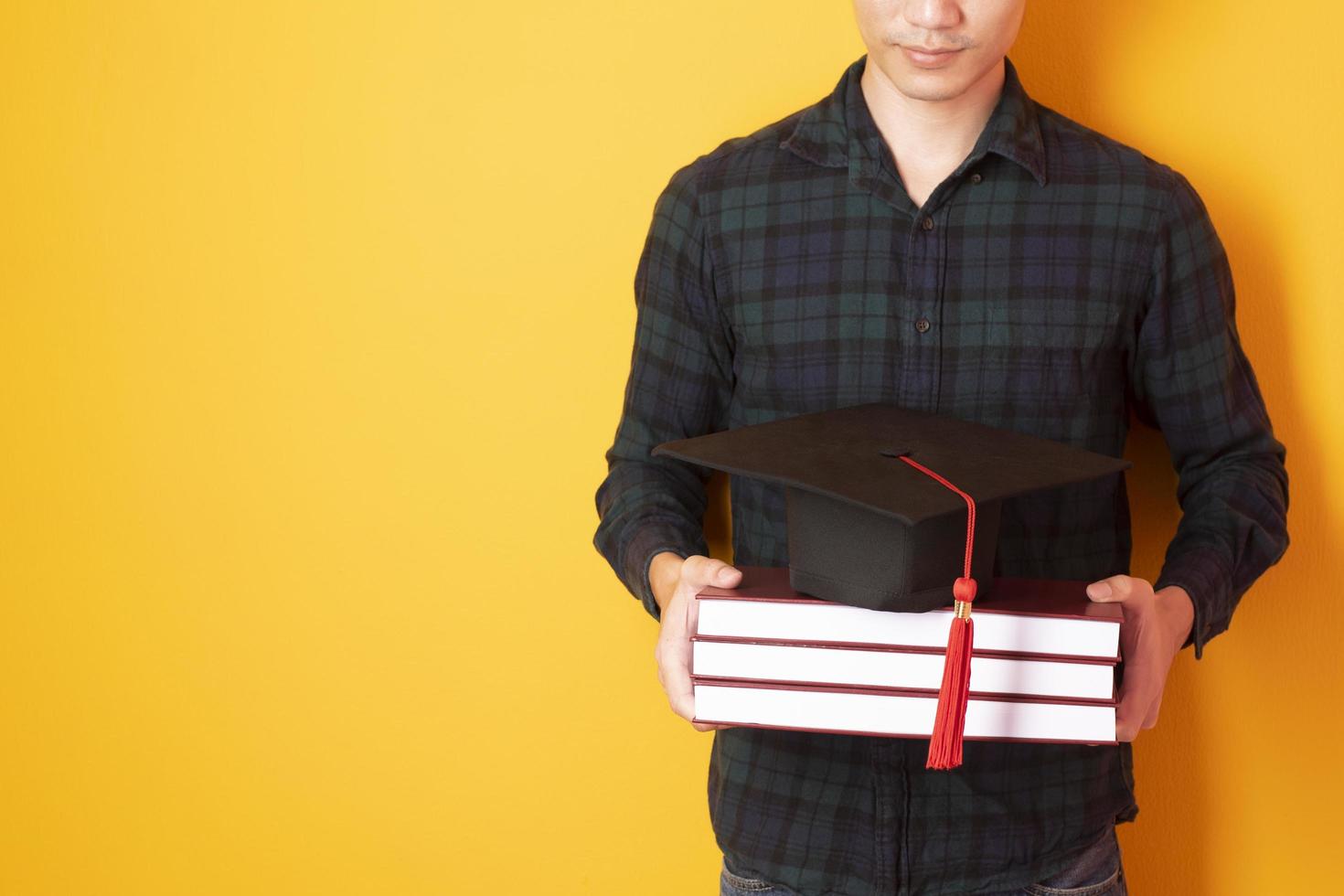 l'uomo dell'università è felice della laurea su sfondo giallo foto