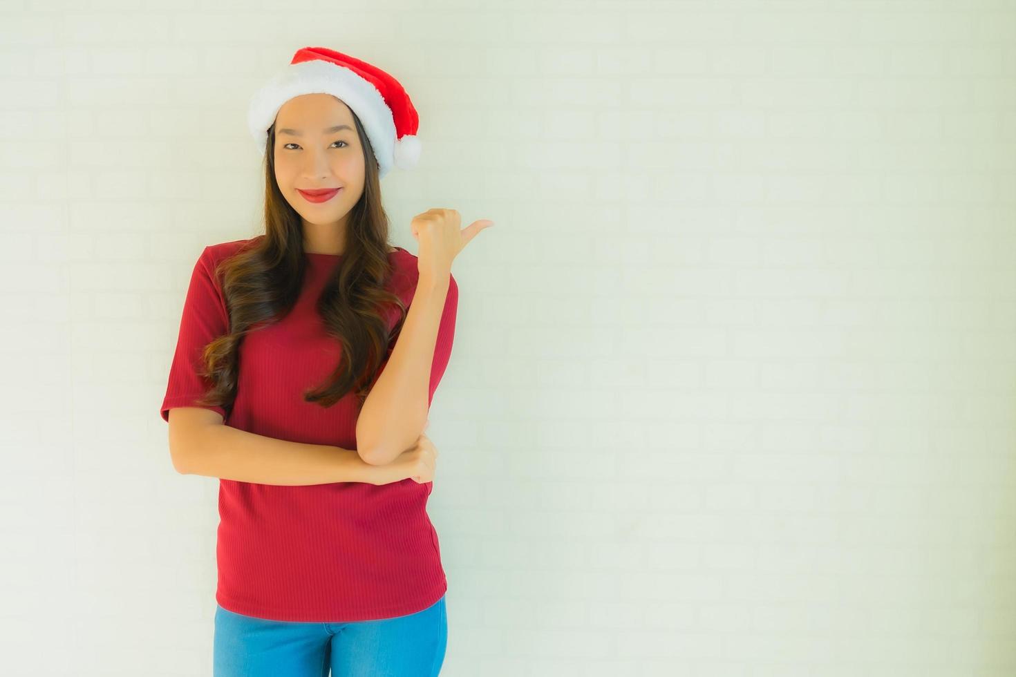 ritratto belle giovani donne asiatiche che indossano il cappello di Babbo Natale per la celebrazione a natale foto