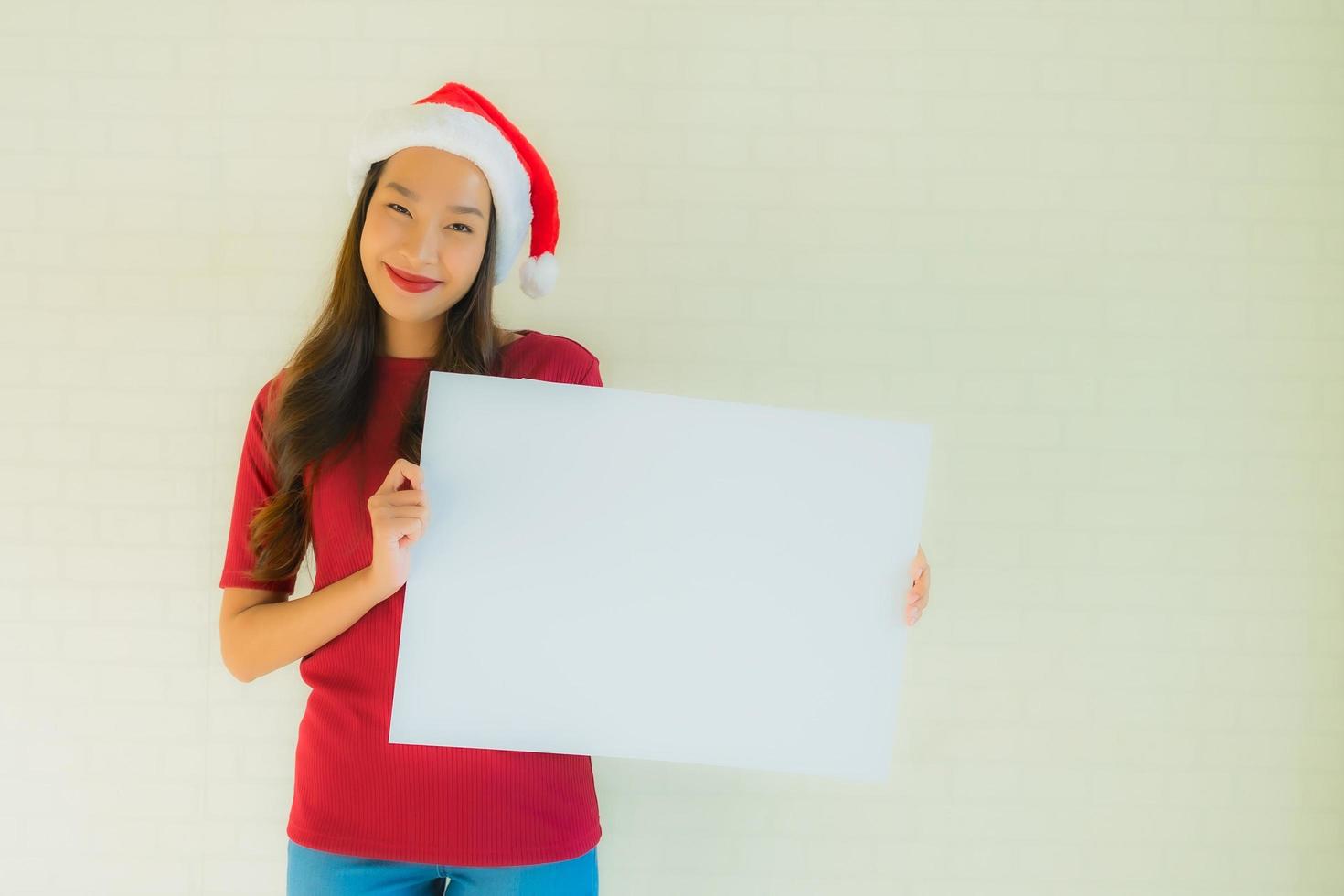 le belle giovani donne asiatiche del ritratto mostrano la carta bianca in bianco del bordo con lo spazio della copia foto