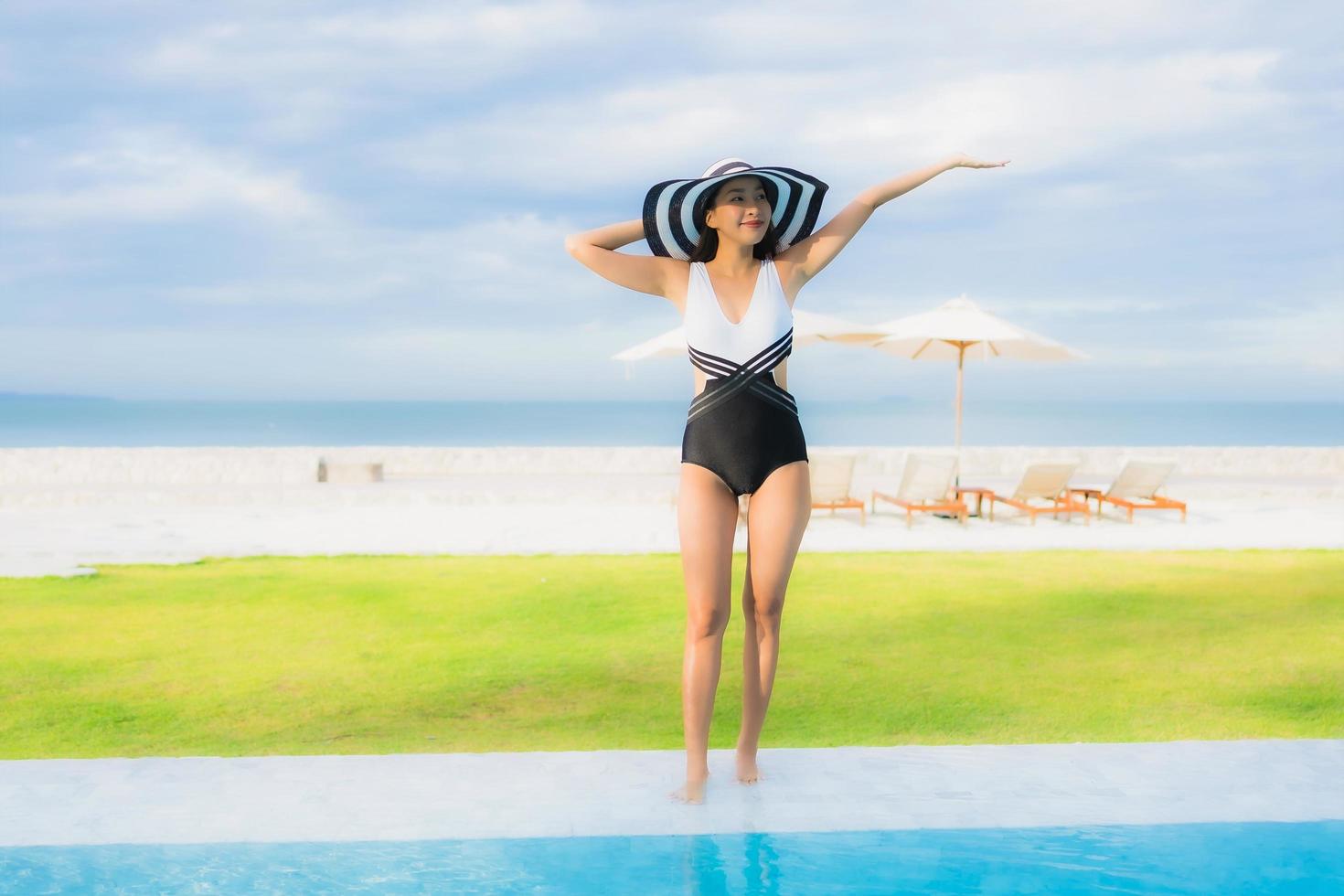 ritratto belle giovani donne asiatiche sorriso felice rilassarsi intorno alla piscina foto