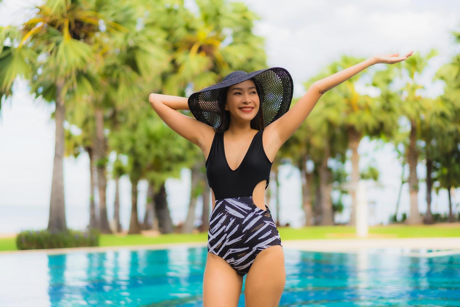 ritratto belle giovani donne asiatiche sorriso felice rilassarsi intorno alla piscina foto