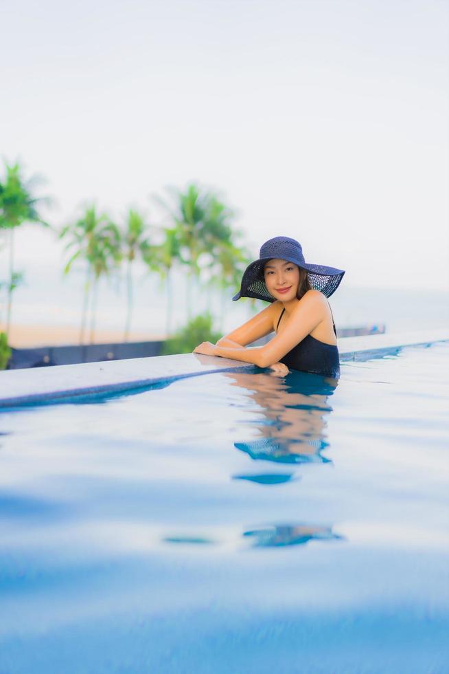 ritratto belle giovani donne asiatiche sorriso felice relax piscina all'aperto in hotel foto