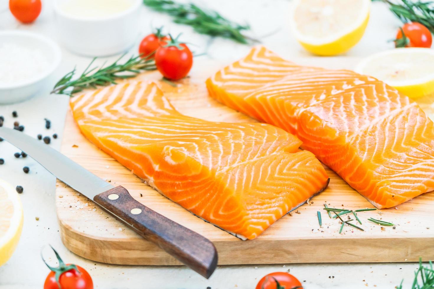 filetto di carne di salmone crudo e fresco sul tagliere di legno foto