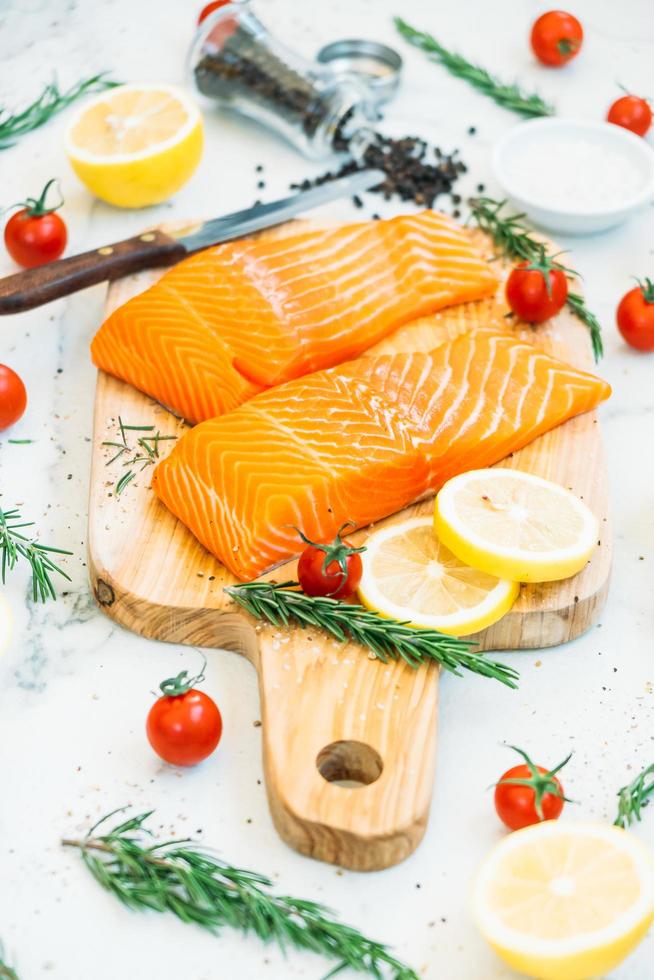 filetto di carne di salmone crudo e fresco sul tagliere di legno foto