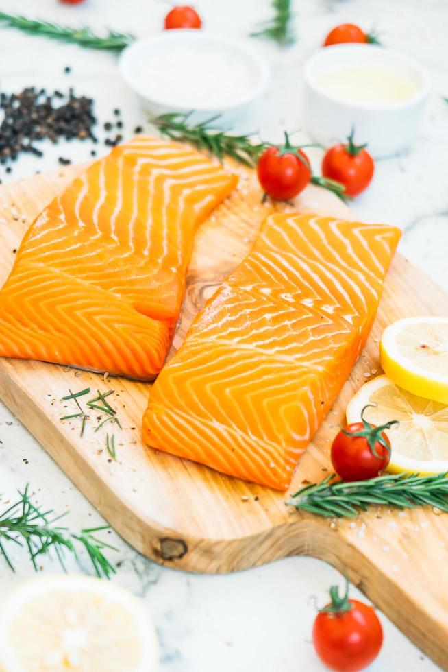 filetto di carne di salmone crudo e fresco sul tagliere di legno foto