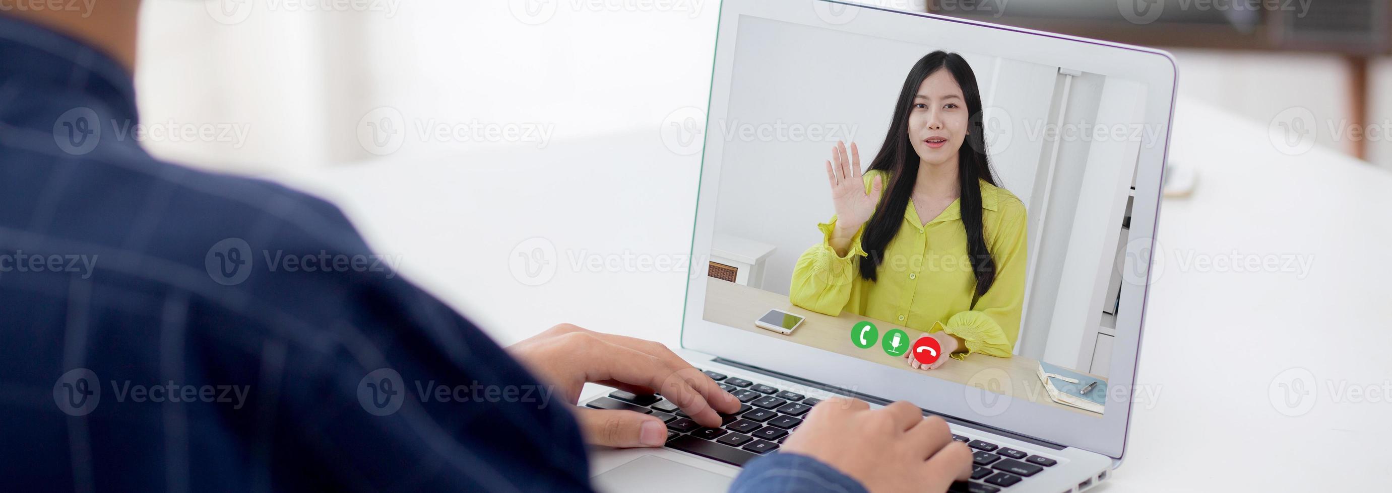 giovane uomo d'affari asiatico e donna videoconferenza online per discussione sulle statistiche della finanza con computer portatile, donna d'affari che spiega il rapporto con l'uomo d'affari, distanza sociale. foto