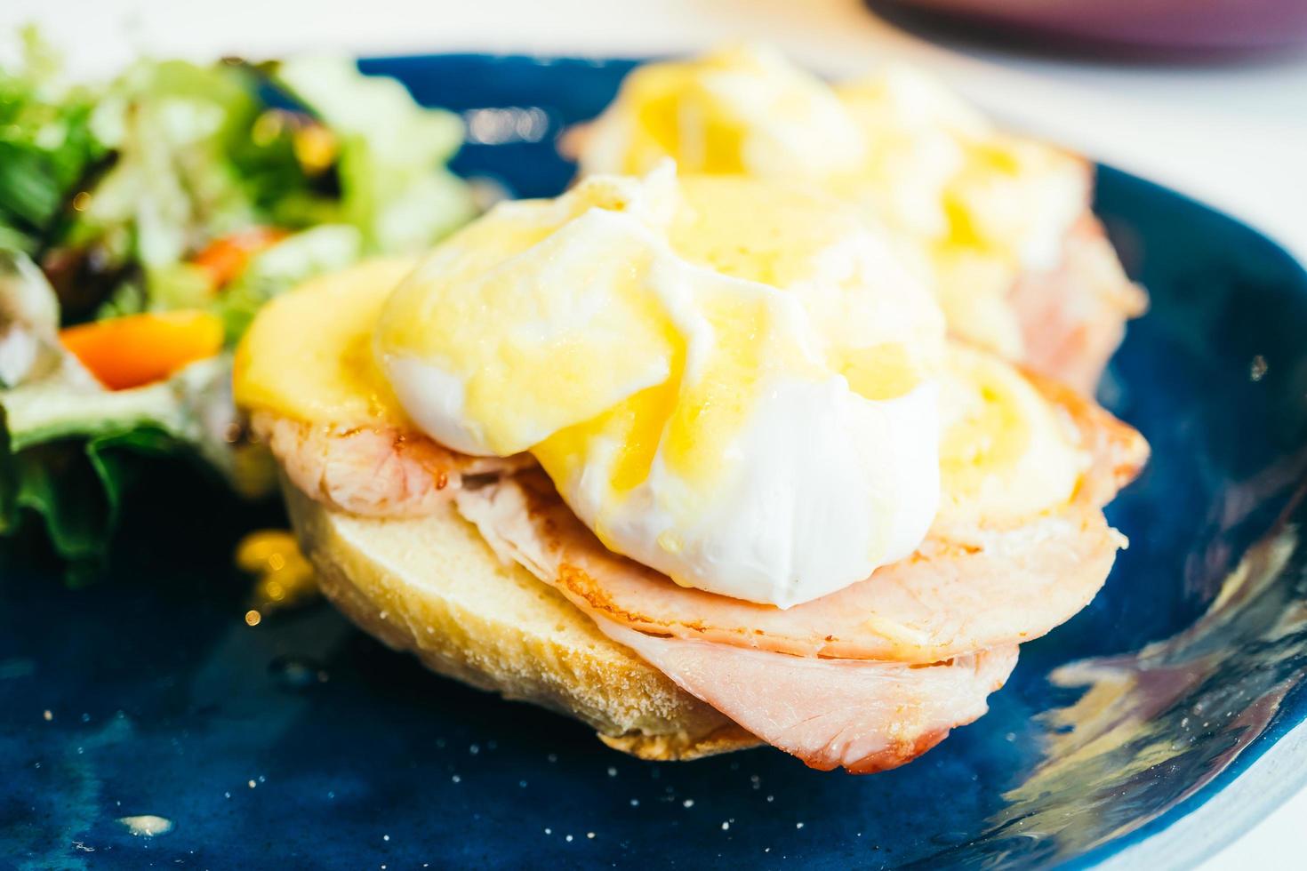 uova alla benedict con prosciutto e salsa in cima foto