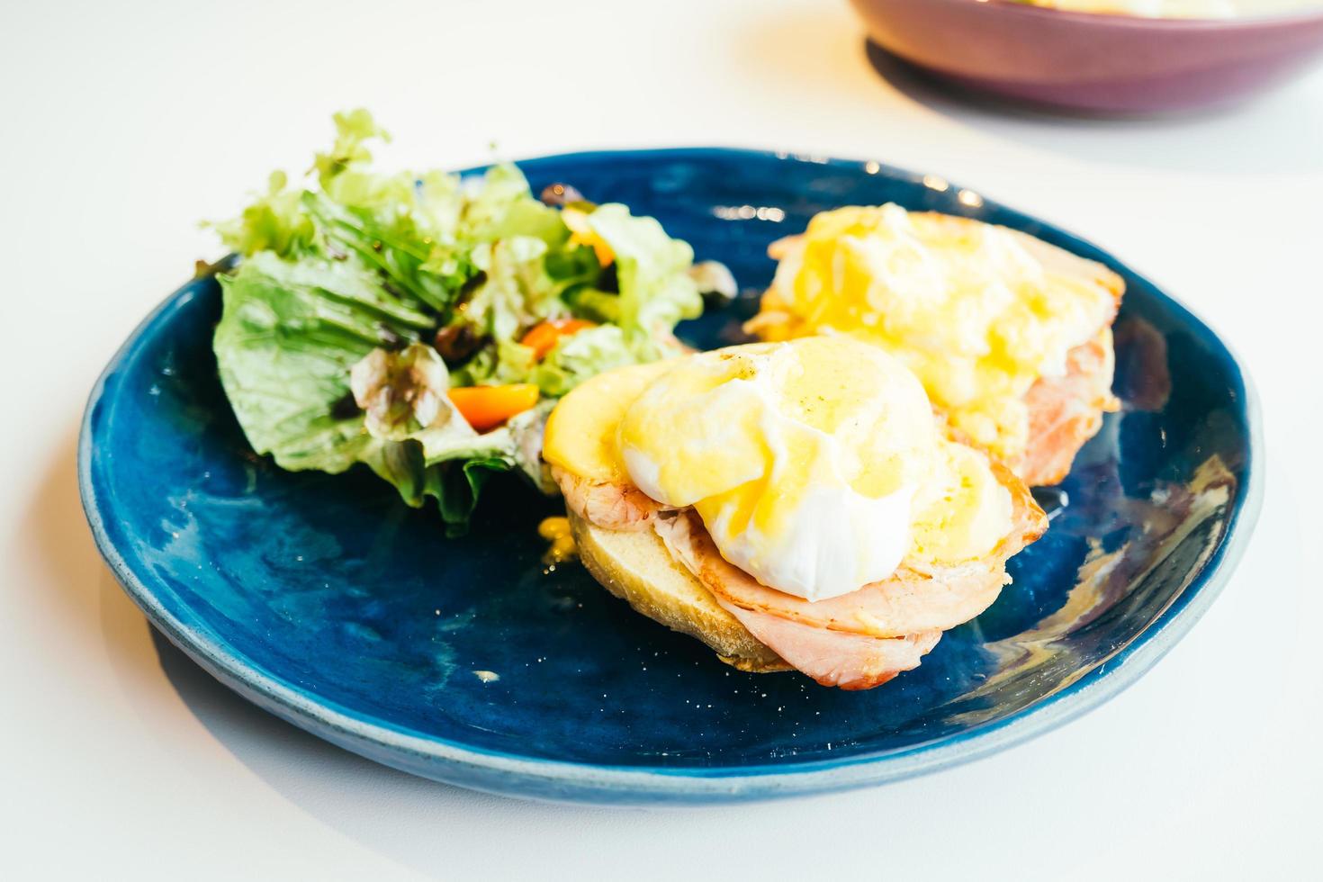 uova alla benedict con prosciutto e salsa in cima foto