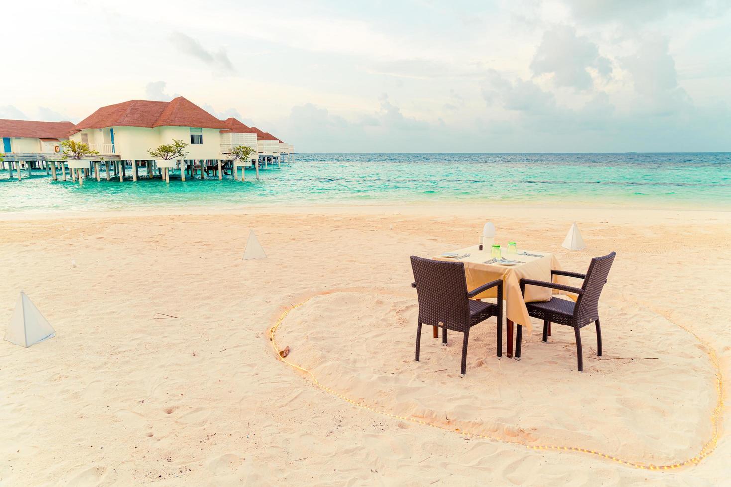 tavolo da pranzo vuoto e sedia sulla spiaggia con sfondo vista mare alle maldive foto