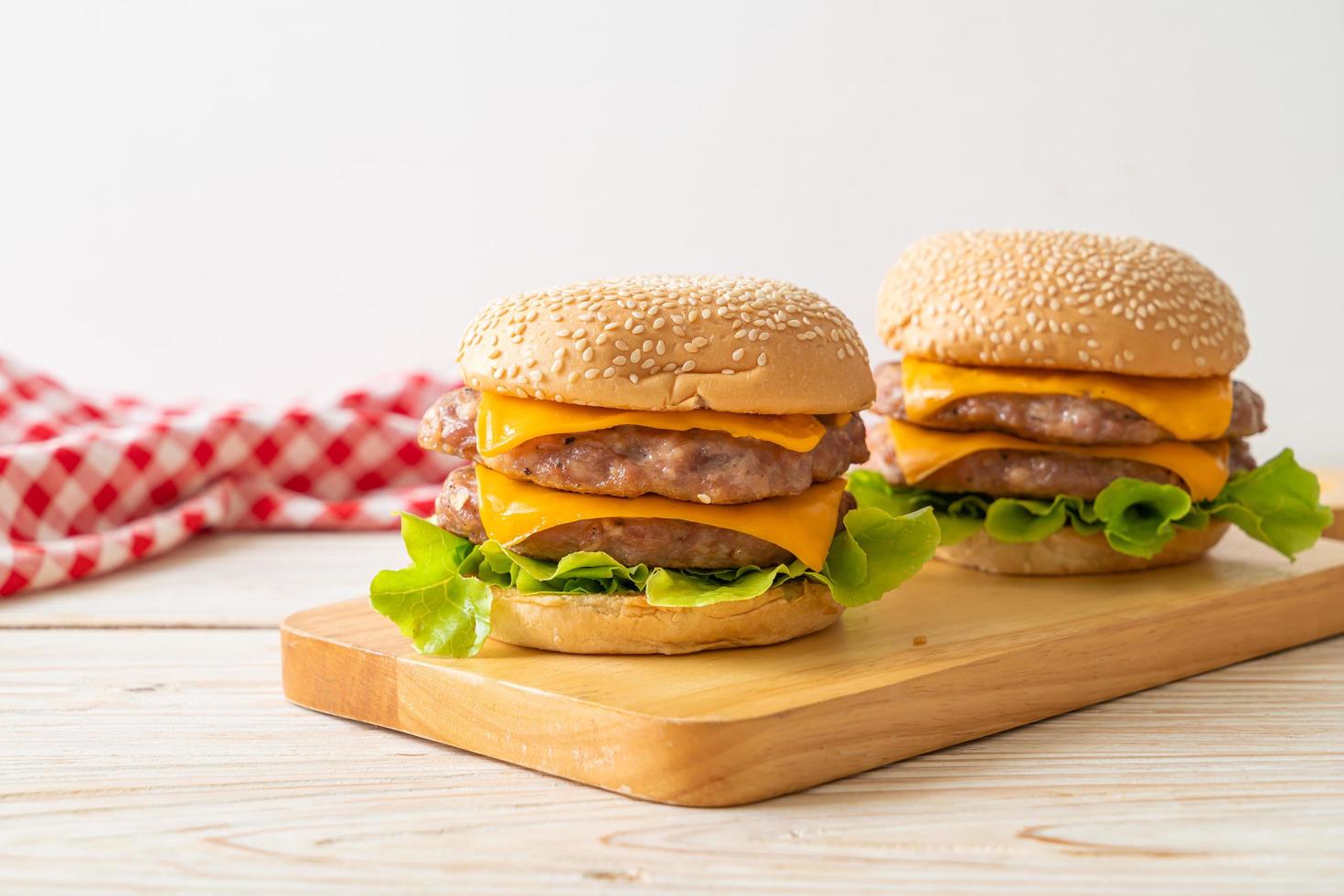 hamburger di maiale o hamburger di maiale con formaggio su tavola di legno foto