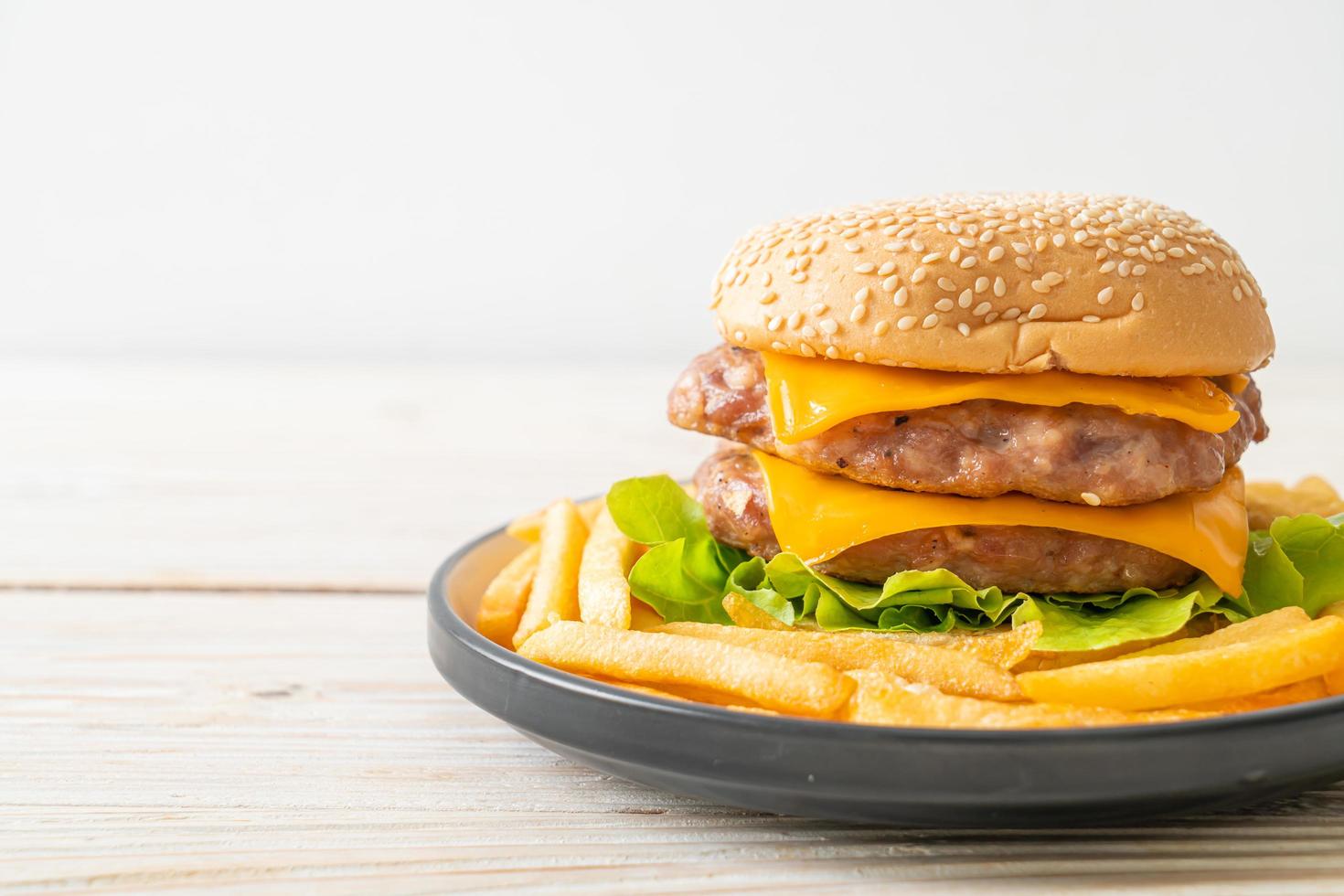 hamburger di maiale o hamburger di maiale con formaggio e patatine fritte foto