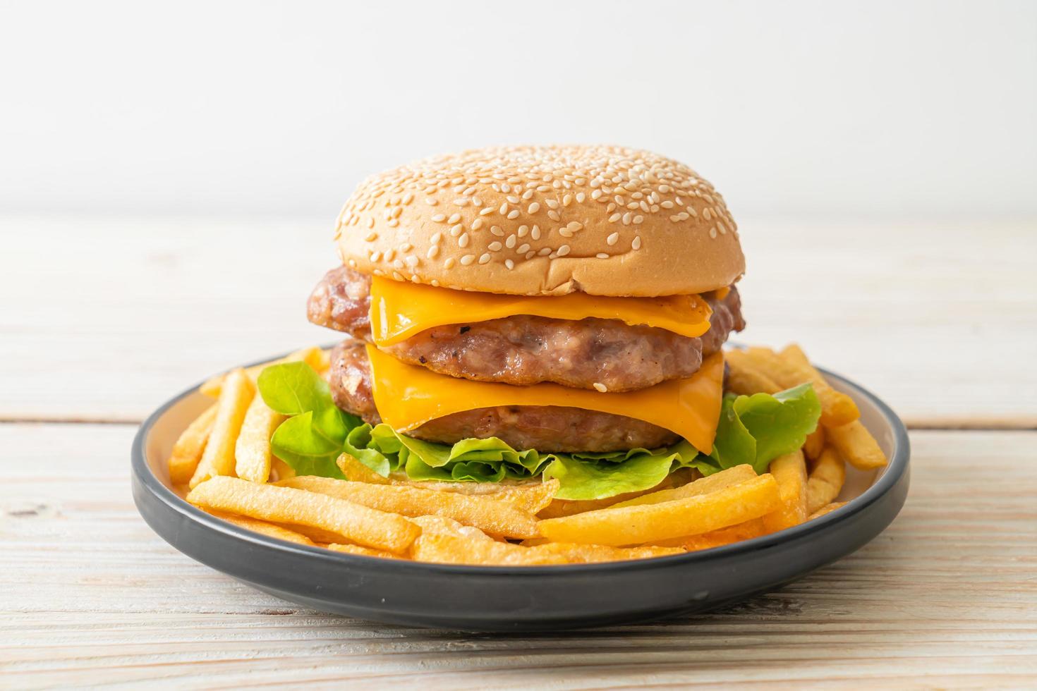 hamburger di maiale o hamburger di maiale con formaggio e patatine fritte foto