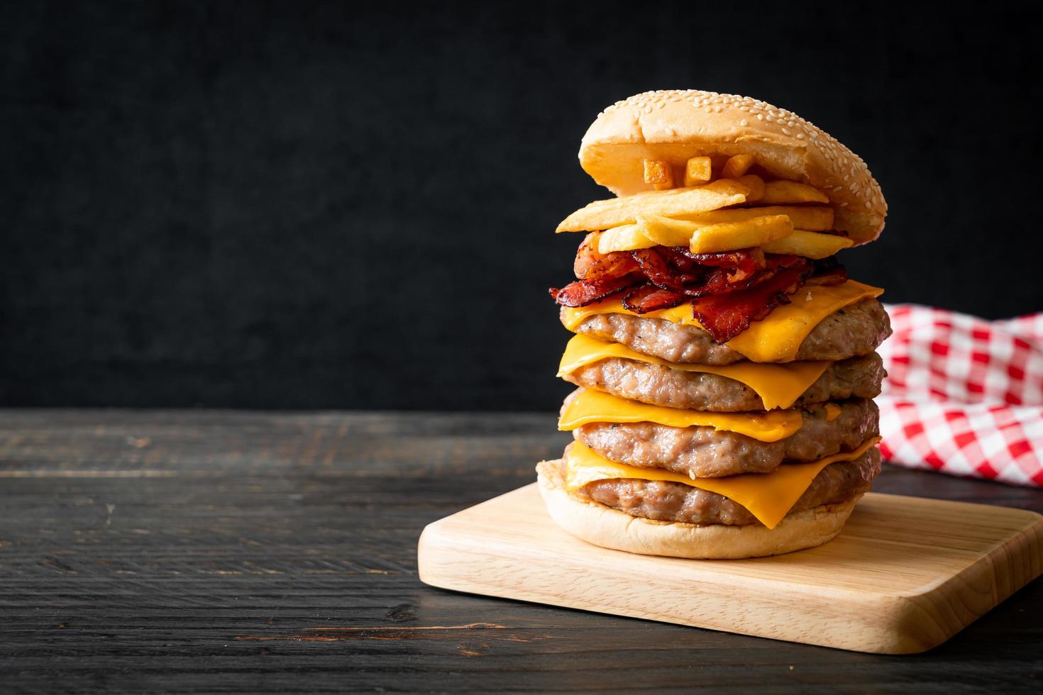 hamburger di maiale o hamburger di maiale con formaggio, pancetta e patatine fritte foto