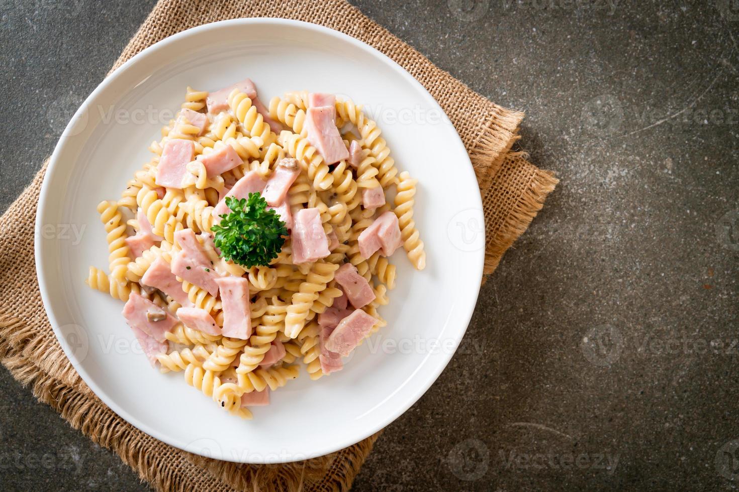 spirali o pasta a spirale salsa di crema di funghi con prosciutto - stile italiano foto