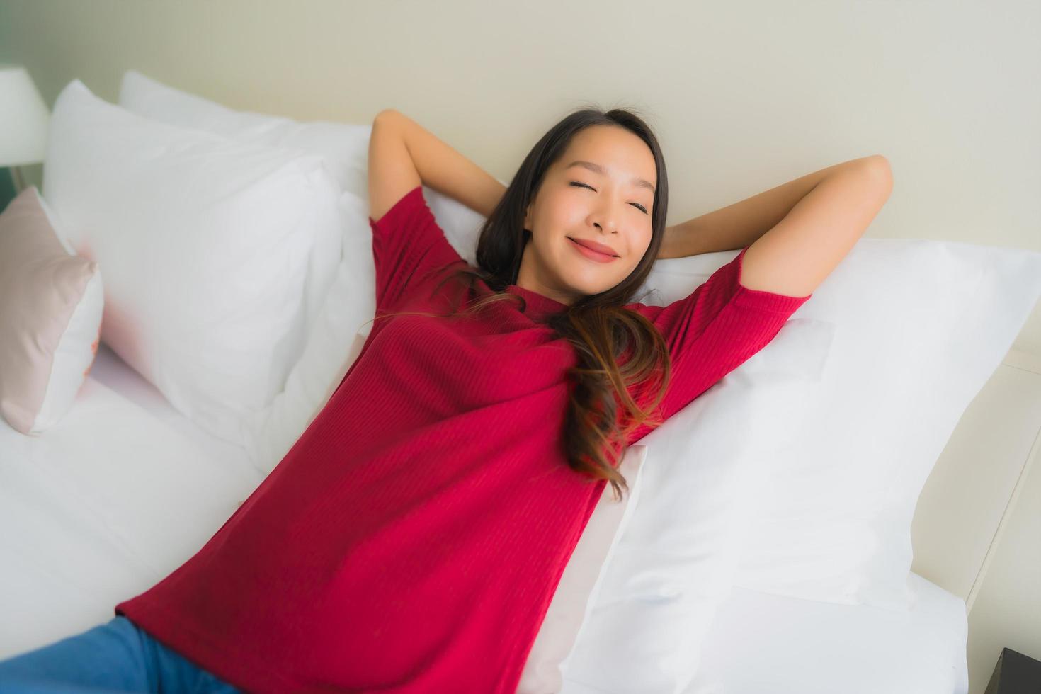 ritratto belle giovani donne asiatiche sorridono felici sul letto foto