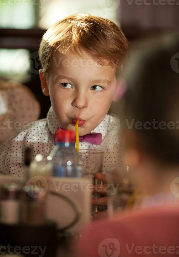 poco ragazzo potabile con tubulo foto