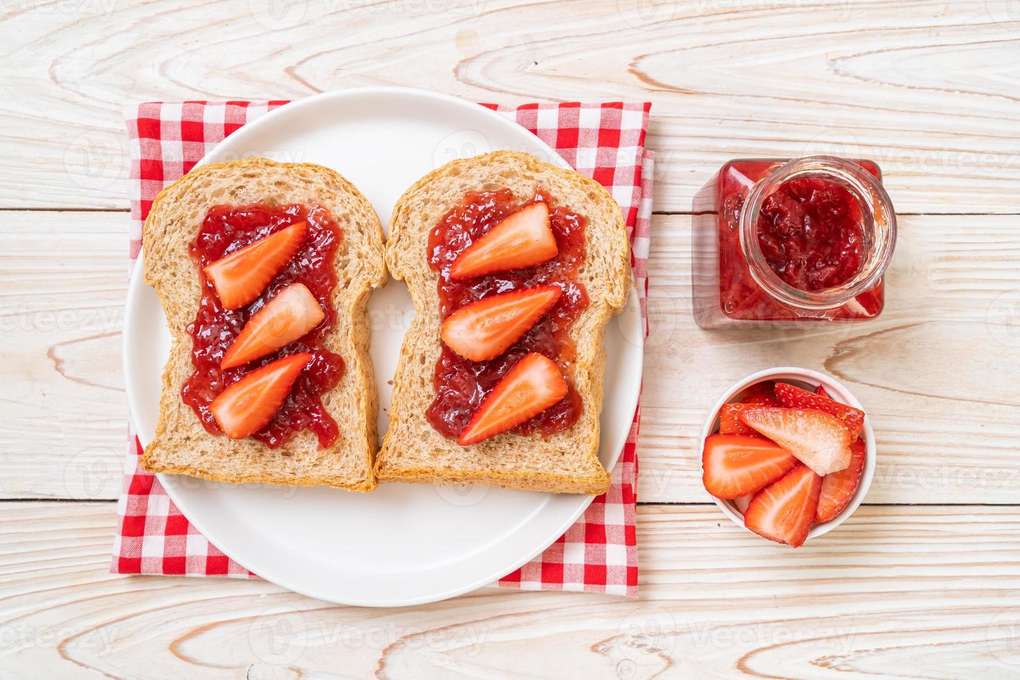 pane integrale fatto in casa con marmellata di fragole e fragole fresche foto