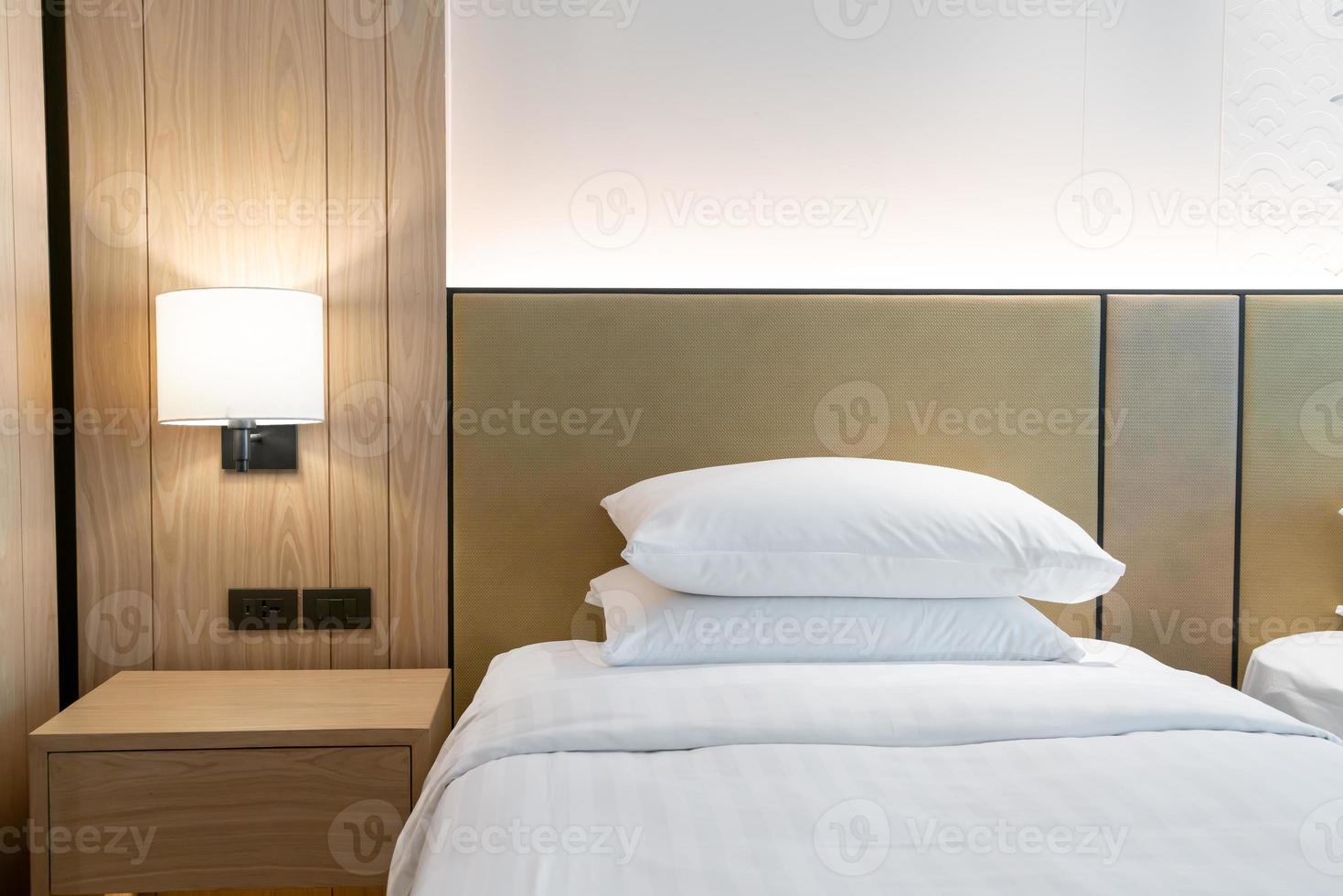 decorazione del cuscino bianco sul letto nella camera da letto del resort dell'hotel foto