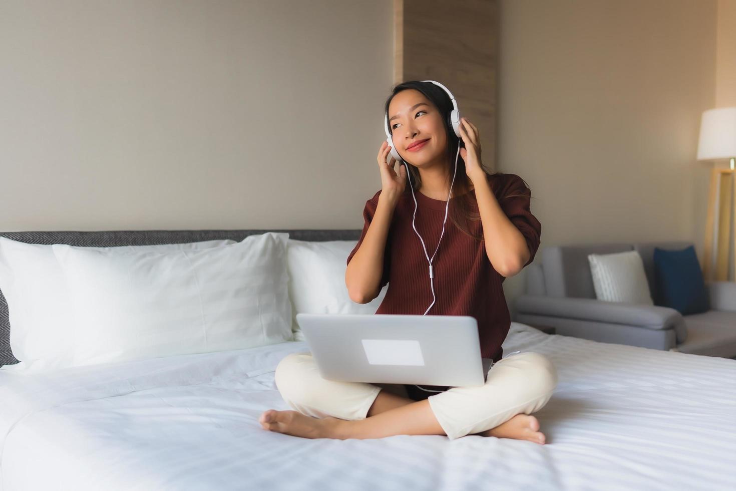 ritratto belle giovani donne asiatiche che utilizzano computer e cuffie per ascoltare musica foto