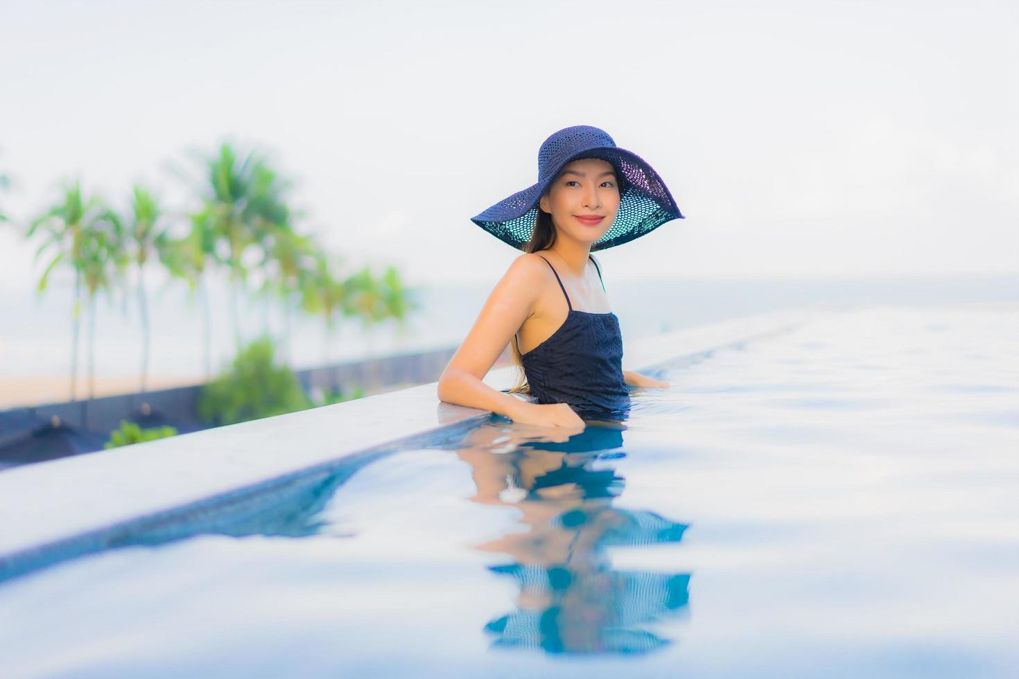 ritratto belle giovani donne asiatiche sorriso felice relax piscina all'aperto in hotel foto