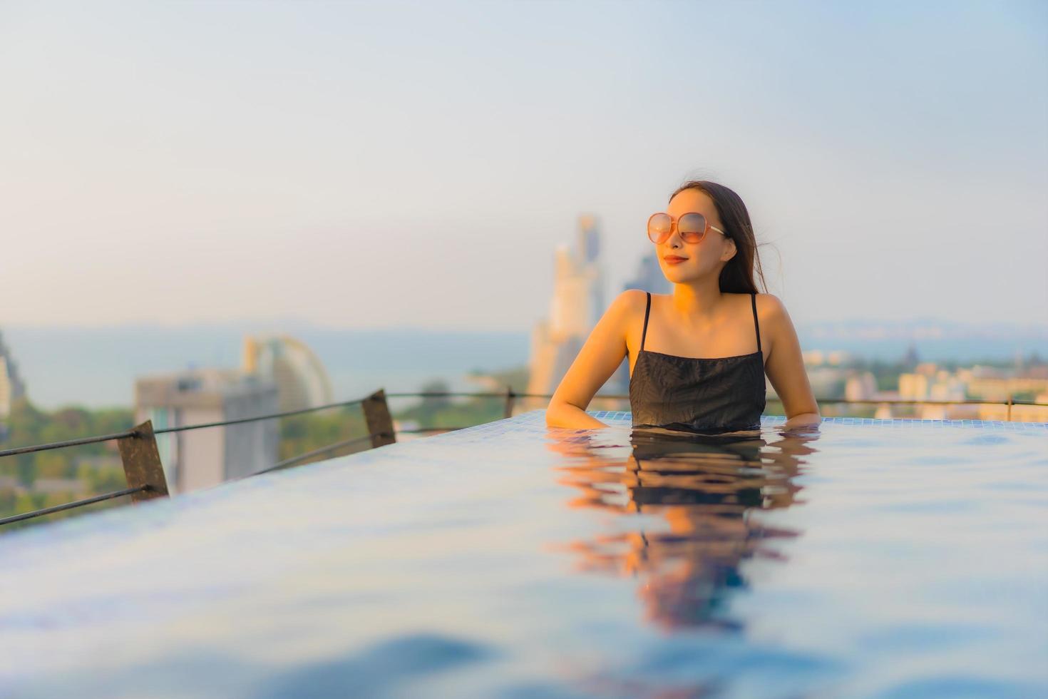 ritratto belle giovani donne asiatiche sorriso felice relax piscina all'aperto in hotel foto